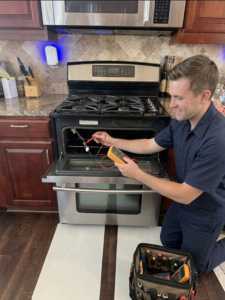 Anchor technician measuring an oven element on a gas range